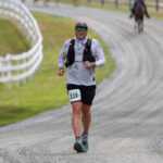 Matthew Hoadley running in an ultramarathon race on a gravel road.